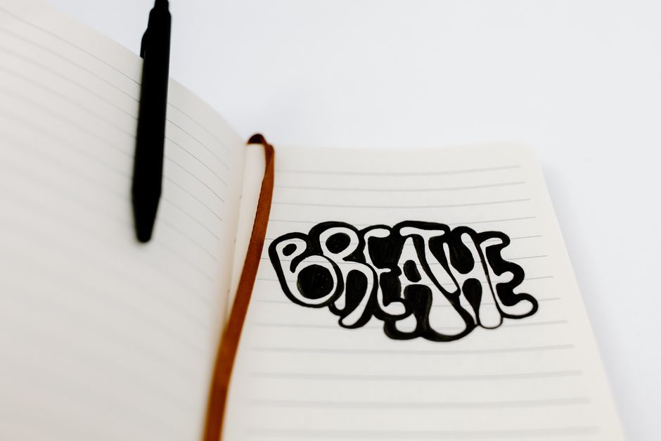 Handwritten 'Breathe' in a notebook, encouraging relaxation and mindfulness.